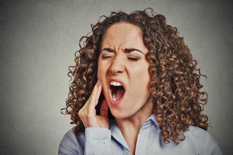 Closeup portrait young woman with sensitive jaw pain